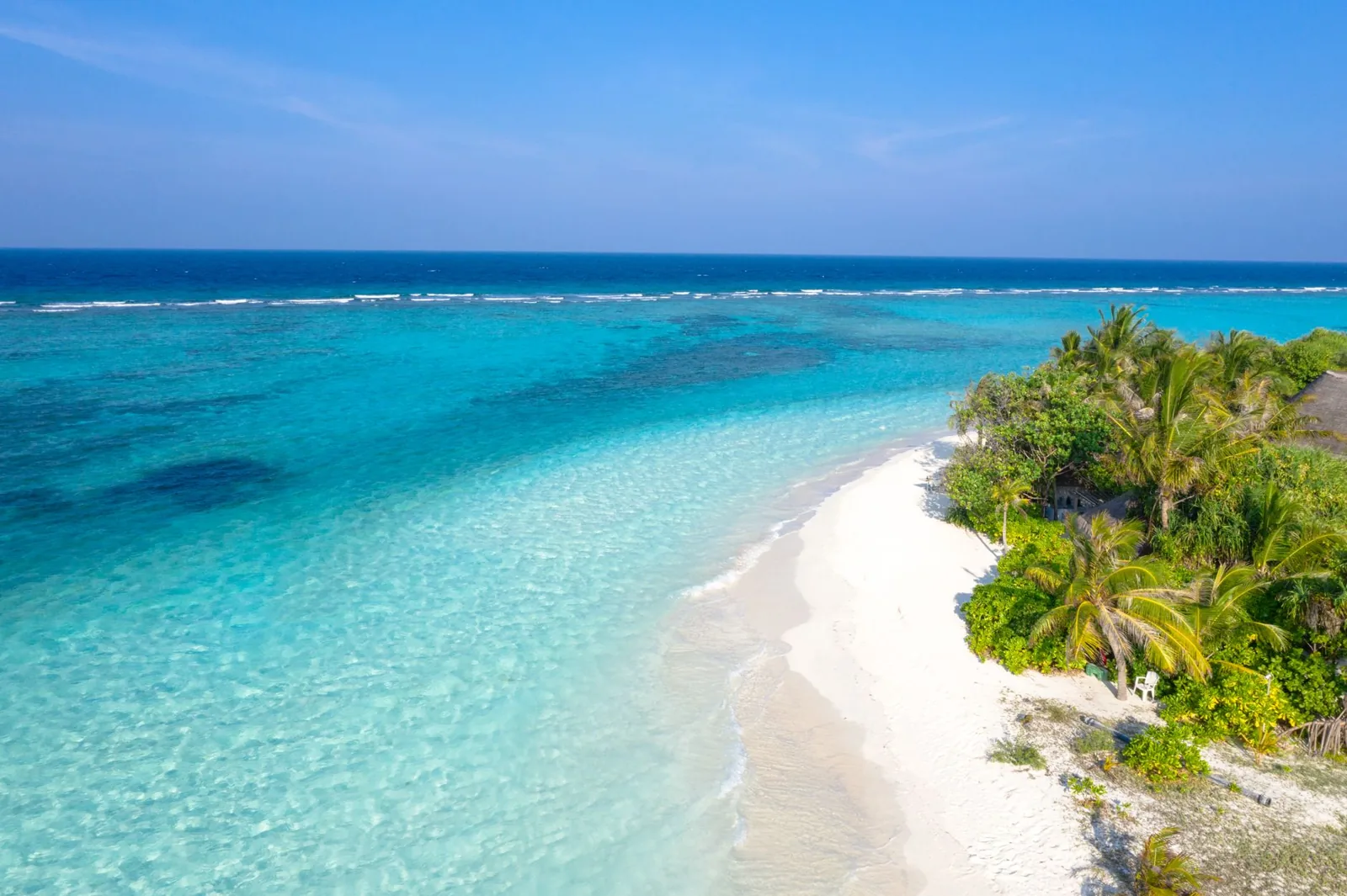 Cheapest tropical destinations across Southeast Asia — a quiet palm-lined beach with turquoise water