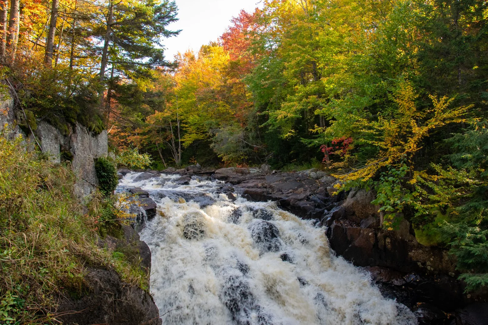 Best places to visit in fall — red maple leaves and a covered bridge in New England